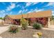 Landscaped front yard with mature plants and a well-maintained brick exterior create curb appeal at 1240 E Indigo St, Mesa, AZ 85203