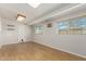 Basement living room with wood-look floors, shelving, and bright windows at 1240 E Indigo St, Mesa, AZ 85203