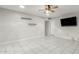 Open living room with neutral tile flooring, ceiling fan, and mounted television at 1240 E Indigo St, Mesa, AZ 85203