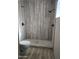 Elegant walk-in shower features wood-look tile, stone floor, and black fixtures at 1358 S Royal Palm Rd, Apache Junction, AZ 85119