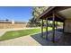 Serene backyard with artificial turf, gravel, and a covered patio for outdoor relaxation and enjoyment at 14017 N 40Th Ave, Phoenix, AZ 85053