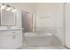 Elegant bathroom with a freestanding tub, framed window, modern fixtures, and marble accents, creating a spa-like retreat at 1777 W Redfield Rd, Gilbert, AZ 85233
