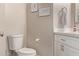 Neutral bathroom featuring a toilet, decorative artwork, and a vanity with modern fixtures at 1777 W Redfield Rd, Gilbert, AZ 85233