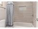 Neutral bathroom showcasing a bathtub and tiled walls with a built-in niche for storage at 1777 W Redfield Rd, Gilbert, AZ 85233