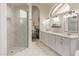 Bright bathroom featuring a glass shower, double vanity, and arched window, offering a modern and spacious design at 1777 W Redfield Rd, Gilbert, AZ 85233
