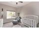 Serene Bedroom featuring a crib, comfortable chair, and soft lighting, creating a peaceful environment at 1777 W Redfield Rd, Gilbert, AZ 85233