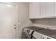 Laundry room with front-loading washer and dryer plus white cabinets for storage at 1777 W Redfield Rd, Gilbert, AZ 85233