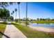 Picturesque walking path alongside a pond lined with palm trees in a serene community at 1777 W Redfield Rd, Gilbert, AZ 85233