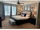 Elegant main bedroom with plush bedding, a ceiling fan, and abundant natural light from large windows at 2487 E Aris Dr, Gilbert, AZ 85298