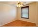 Cozy bedroom featuring a ceiling fan, wood-look flooring, and a window with wood-slat blinds at 2873 S Arroyo Ln, Gilbert, AZ 85295