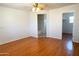 Bedroom features wood floors, white walls, and natural light coming from a door and a hallway at 2873 S Arroyo Ln, Gilbert, AZ 85295