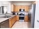 Well-lit kitchen featuring stainless steel appliances and light wood cabinetry at 2873 S Arroyo Ln, Gilbert, AZ 85295