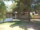Backyard featuring screened in patio, mature trees and block wall at 4718 W El Caminito Dr, Glendale, AZ 85302
