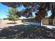 Well-kept backyard featuring lush lawn, mature trees, and a covered patio at 4718 W El Caminito Dr, Glendale, AZ 85302