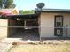 Backyard featuring a covered parking space, fence, and small window at 4718 W El Caminito Dr, Glendale, AZ 85302