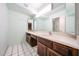 Bathroom featuring a double vanity with mirrors and white tiled floors at 4718 W El Caminito Dr, Glendale, AZ 85302