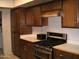 Kitchen showcasing stove, oven, range hood and stained cabinets at 4718 W El Caminito Dr, Glendale, AZ 85302