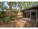 Landscaped backyard featuring a screened-in patio and mature trees at 1014 W Hononegh Dr, Phoenix, AZ 85027
