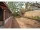 A spacious backyard featuring a screened-in patio, mature trees, and a brick-lined garden at 1014 W Hononegh Dr, Phoenix, AZ 85027