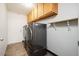 A dedicated laundry room with washer, dryer, storage cabinets, and tile floors at 1014 W Hononegh Dr, Phoenix, AZ 85027
