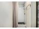 Modern bathroom showcasing white tile shower, glass shelving, and brass hardware at 1025 E Northern Ave, Phoenix, AZ 85020