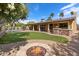 Outdoor living space boasts a fire pit, built-in BBQ area, and lush lawn at 10896 N 105Th Way, Scottsdale, AZ 85259
