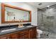 Modern bathroom featuring a dual sink vanity, a large framed mirror, and a tiled shower at 10896 N 105Th Way, Scottsdale, AZ 85259