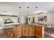 Spacious kitchen showcasing a granite island with pendant lighting open to a dining area and living room at 10896 N 105Th Way, Scottsdale, AZ 85259