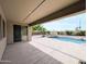 Relaxing back patio with covered area, a pool, and lush landscaping for outdoor enjoyment at 14703 W Hillside St, Goodyear, AZ 85395