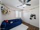 Bright bedroom featuring a cozy blue sofa, plush rug, and charming decorative accents at 14703 W Hillside St, Goodyear, AZ 85395