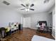 The light-filled bedroom features wood floors, a ceiling fan, and a door to another room at 14703 W Hillside St, Goodyear, AZ 85395