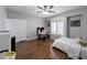 Spacious bedroom with wood floors features a ceiling fan, desk, and window with shutters at 14703 W Hillside St, Goodyear, AZ 85395