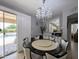 Chic dining room with a round table, chandelier, and sliding door access to the backyard pool area at 14703 W Hillside St, Goodyear, AZ 85395