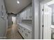 Hallway featuring tiled floors, plenty of cabinet space, and doorways to additional rooms, enhancing accessibility at 14703 W Hillside St, Goodyear, AZ 85395