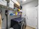 Functional laundry room with modern washer and dryer, ample shelving, and storage space at 14703 W Hillside St, Goodyear, AZ 85395