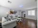 Living room with hardwood floors, gray couches, plantation shutters, mirrored decor, and a view of the workout room at 14703 W Hillside St, Goodyear, AZ 85395