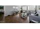 Cozy living room with mirrored accents, plantation shutters, hardwood floors, and gray couches at 14703 W Hillside St, Goodyear, AZ 85395