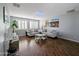 Living room showcasing hardwood floors, gray couches, plantation shutters, mirrored decor, and neutral paint at 14703 W Hillside St, Goodyear, AZ 85395