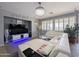 Bright living area with a comfortable white sectional, contemporary decor, and large windows with shutters at 14703 W Hillside St, Goodyear, AZ 85395