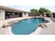 Sparkling pool surrounded by a spacious patio, mature trees, and comfortable lounge chairs at 14703 W Hillside St, Goodyear, AZ 85395