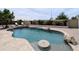 Beautiful swimming pool surrounded by lush greenery, stone accents, and a relaxing lounge area at 14703 W Hillside St, Goodyear, AZ 85395