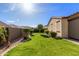 Landscaped backyard with grass at 16229 W Jenan Dr, Surprise, AZ 85379