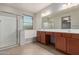 Bathroom featuring glass shower, soaking tub, double sink vanity with neutral color palette at 16229 W Jenan Dr, Surprise, AZ 85379