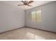 Neutral bedroom featuring tile flooring, a ceiling fan, and natural light at 16229 W Jenan Dr, Surprise, AZ 85379