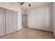 Spacious bedroom with neutral walls, tiled floors, ceiling fan, and closet space at 16229 W Jenan Dr, Surprise, AZ 85379