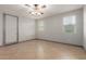 Bright bedroom features two windows, ceiling fan, and neutral tones to offer a calming space at 16229 W Jenan Dr, Surprise, AZ 85379