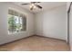 Bedroom featuring tiled floors, neutral paint, and a window overlooking the neighborhood at 16229 W Jenan Dr, Surprise, AZ 85379