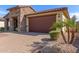 Attractive home with a tile roof, a two-car garage, desert landscaping and a paver driveway at 16229 W Jenan Dr, Surprise, AZ 85379