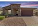 Charming single-story home featuring a stone facade, low maintenance yard, and a two car garage at 16229 W Jenan Dr, Surprise, AZ 85379
