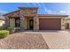 Charming home featuring a stone facade, a two-car garage and a low maintenance front yard at 16229 W Jenan Dr, Surprise, AZ 85379